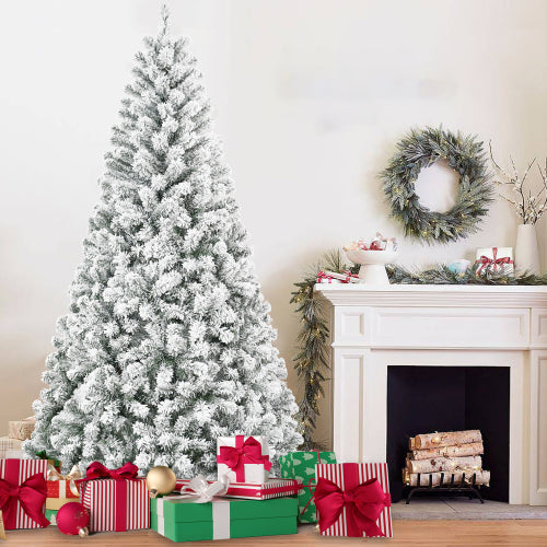 Frosted Christmas tree with presents and a fireplace decorated with a wreath and logs.