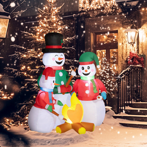 Inflatable snowmen with a campfire in a festive outdoor setting with lights and snow.