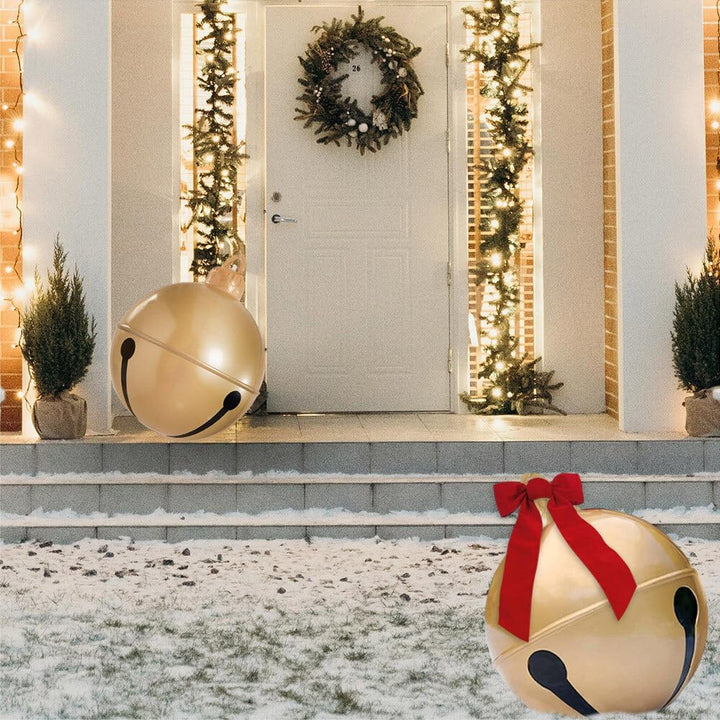 Decorative jingle bell with a red ribbon in front of a house entrance decorated for Christmas.