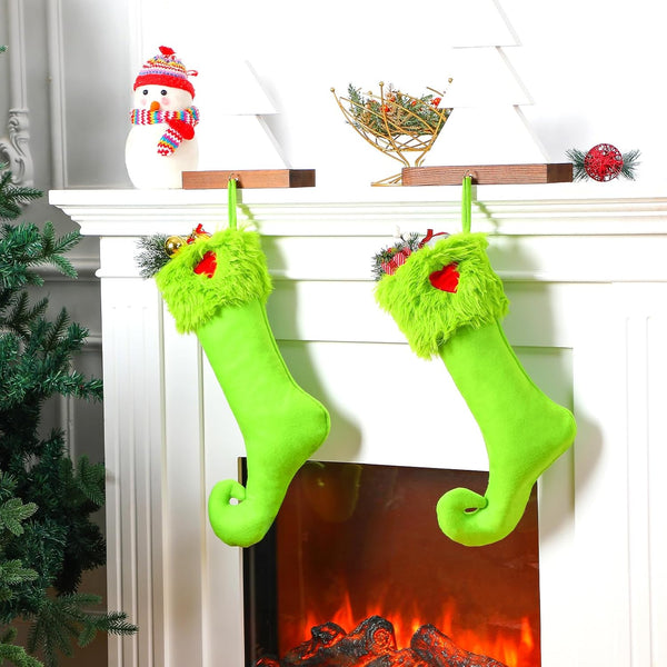 Grinch Green Christmas stockings with red accents hanging on a fireplace mantle.