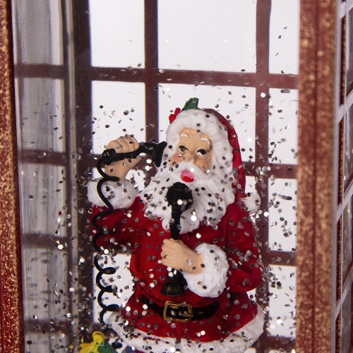 Decorative Santa Claus figure with a microphone in front of a window with snow falling.