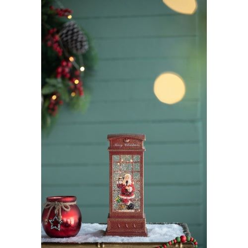 Decorative Christmas scene with a Santa Claus figure in a glass case, surrounded by festive elements
