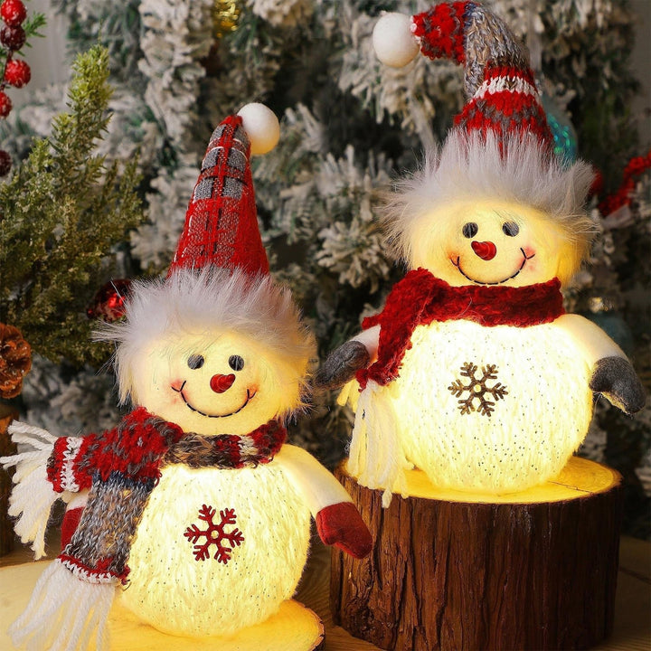 Two LED light-up snowman figurines with festive hats and scarves in front of a Christmas tree.