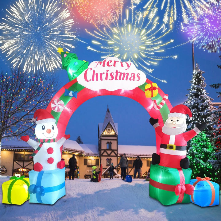 Inflatable Christmas arch with Santa and snowman, fireworks in the sky, and people in the background.