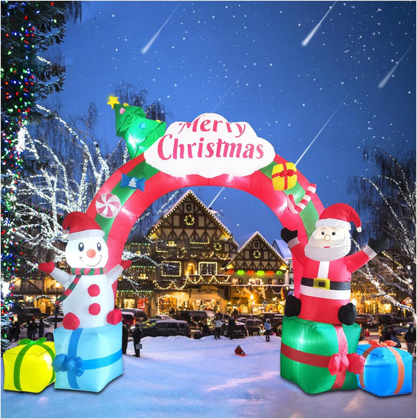 Inflatable Christmas arch with Santa and snowman decorations in a snowy outdoor setting.