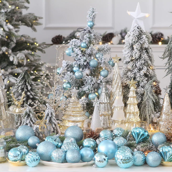Decorative Christmas scene with flocked trees, blue ornaments, and a white fireplace.