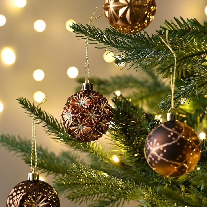 Decorative Christmas ornaments on a tree with a warm glow in the background