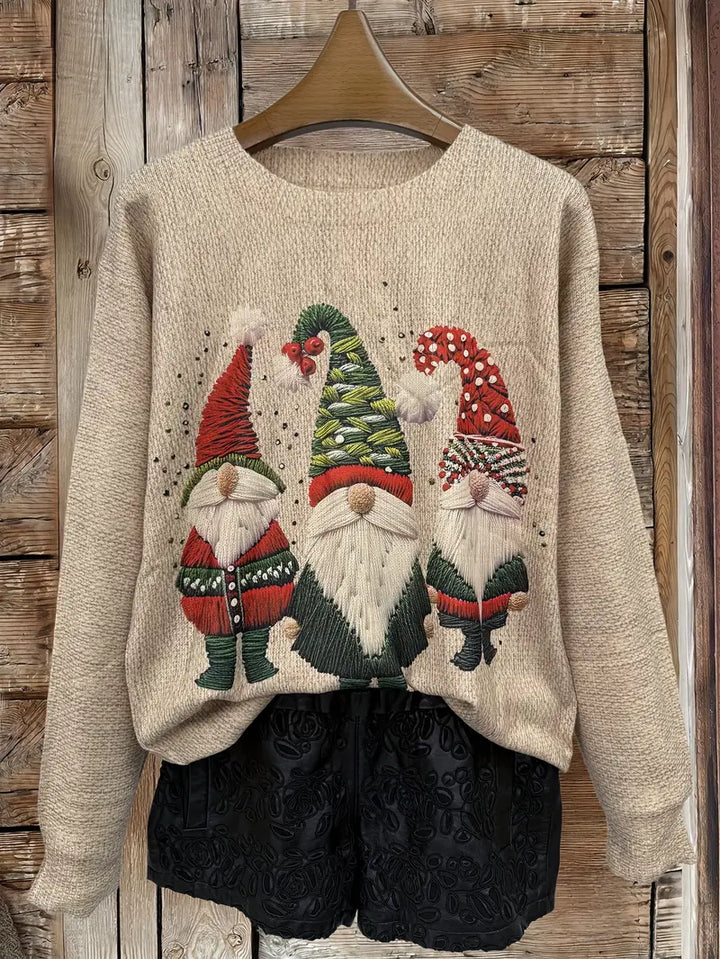 Beige sweater with Christmas-themed gnomes on a wooden background